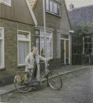 OVI-00000602 mevrouw met fiets voor haar woning Dorpsstraat